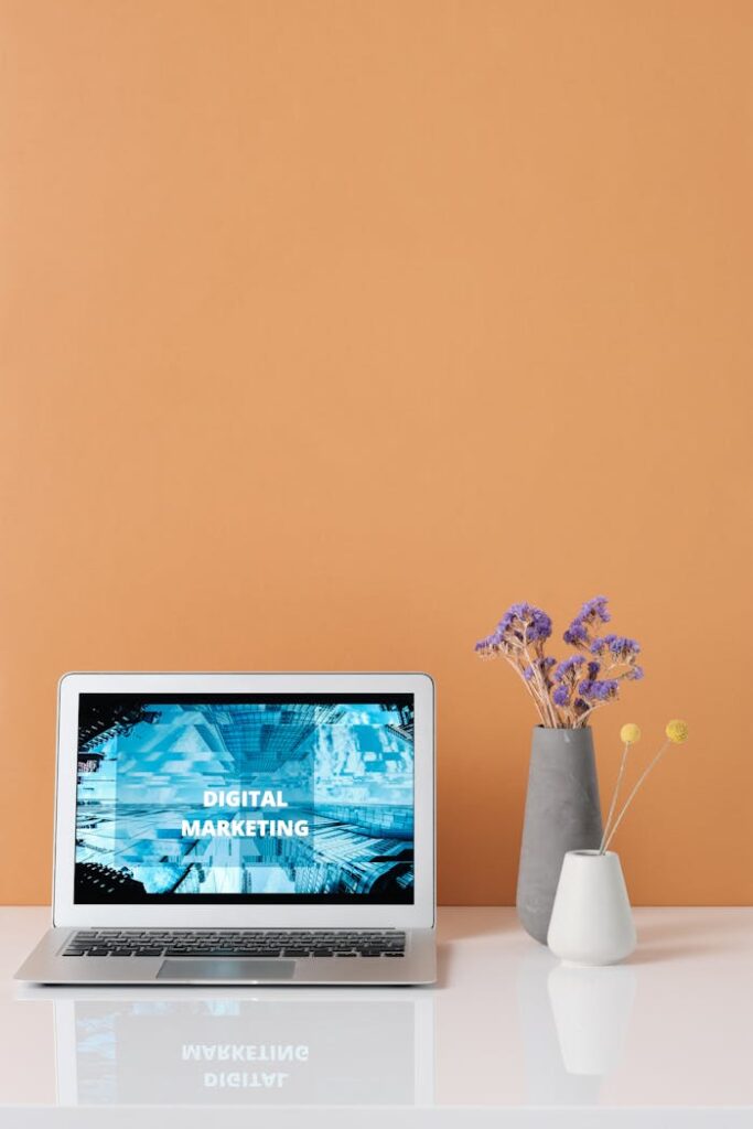 Modern workspace with laptop and decorative flowers showcasing digital marketing.